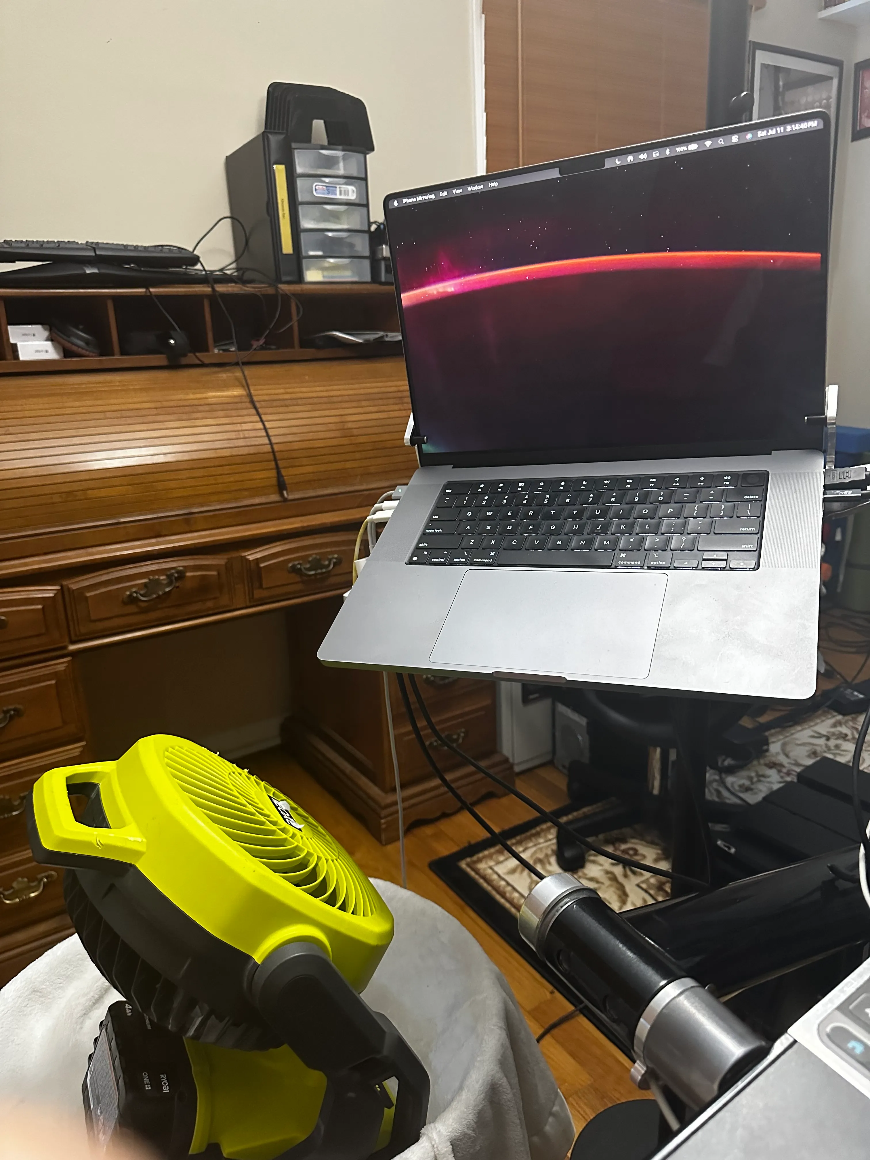 A shop fan pointed at a laptop to keep it cool during LoRA training